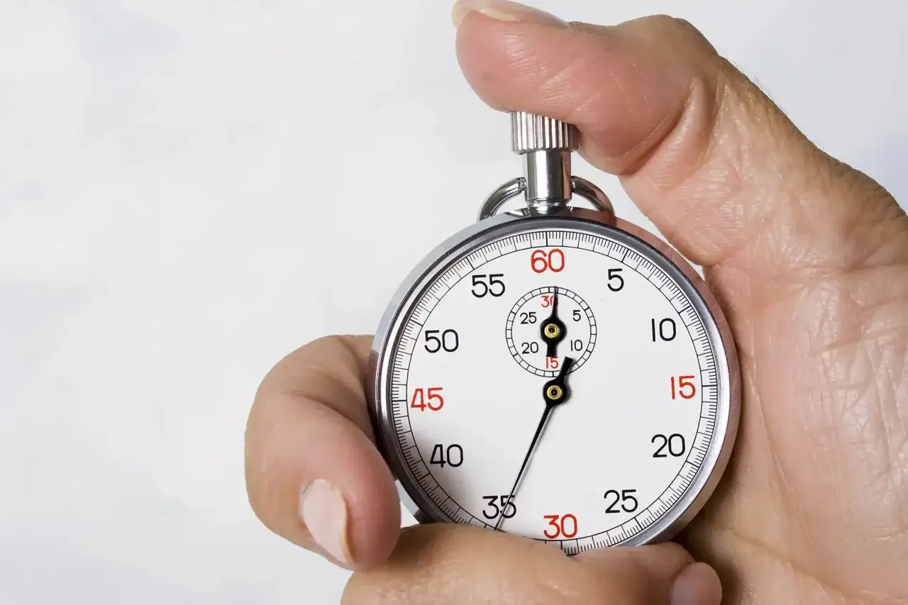 Dłoń trzymająca stoper z tarczą wskazującą czas.