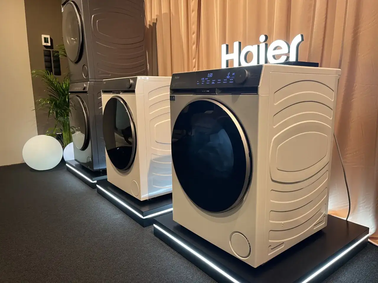 Nowoczesne pralki Haier, znanej firmy z branży AGD, prezentowane na wystawie.