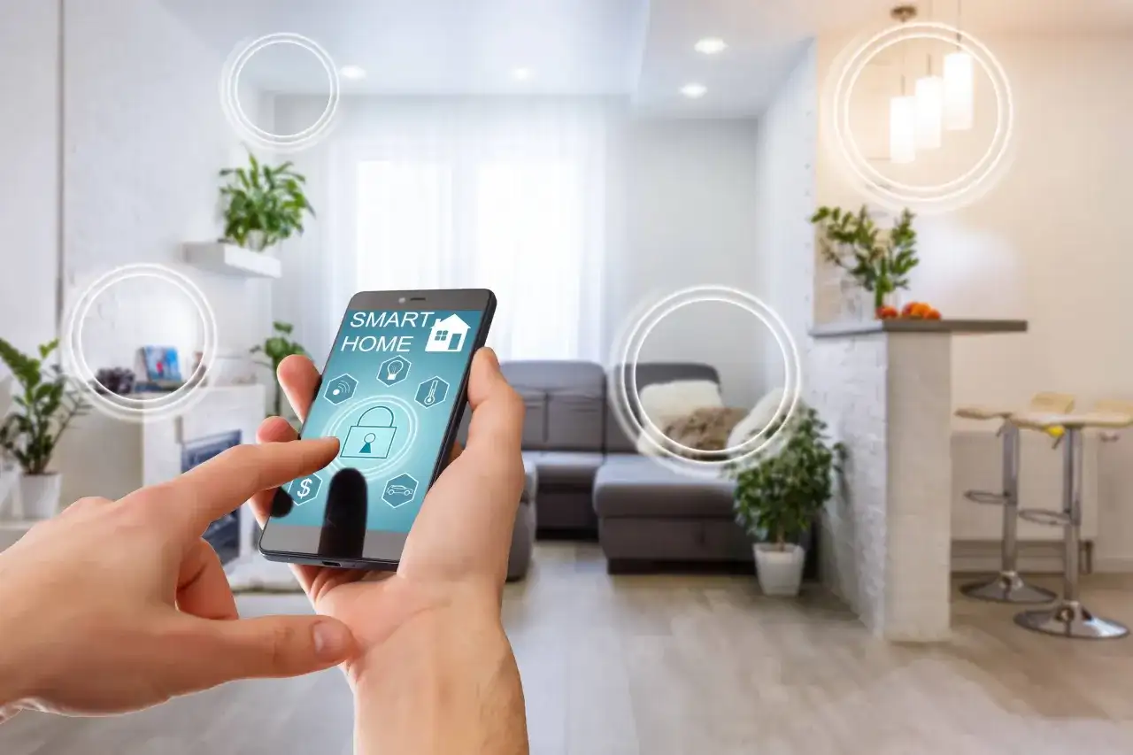 Dłoń steruje aplikacją "Smart Home" na telefonie, symbolizującą inteligentne życie i komfortowe mieszkanie.