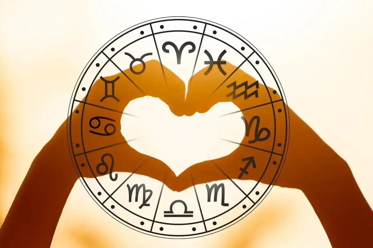 Dłonie tworzą serce w kole zodiaku. Sprawdź horoskop na przyszły tydzień dla Bliźniąt i odkryj swój los.