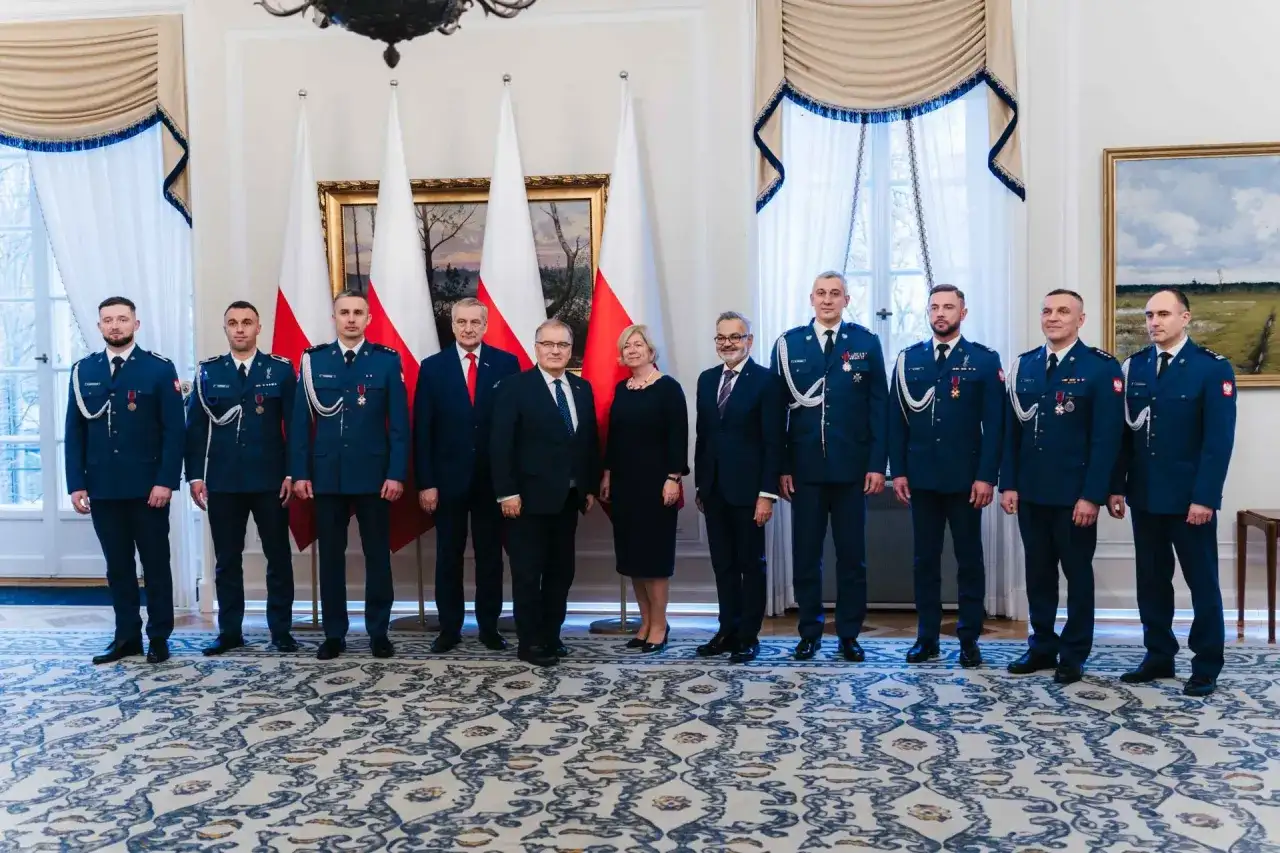 Grupa osób w mundurach i garniturach, być może związana z sekrety ochrony prezydenta i incydenty z drona pod rezydencją w marcu 2026.