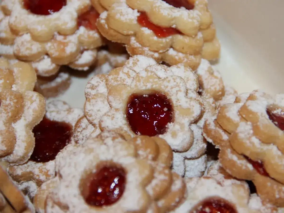 Stos ciastek maślanych z dżemem, oprószonych cukrem pudrem. Idealne na popołudniową herbatę.