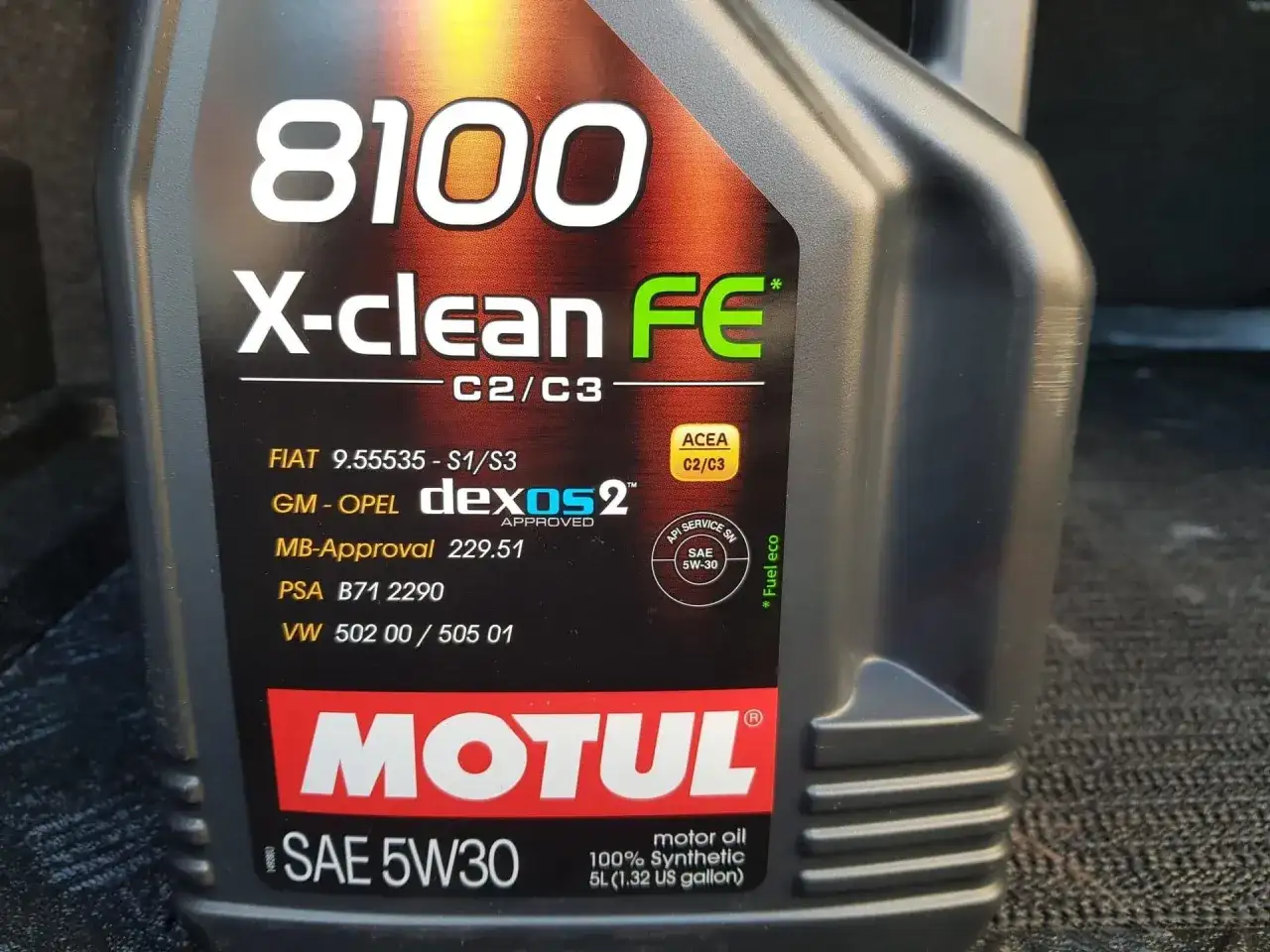 Czarna butelka oleju silnikowego Motul 8100 X-clean FE 5W30 z widocznymi specyfikacjami.