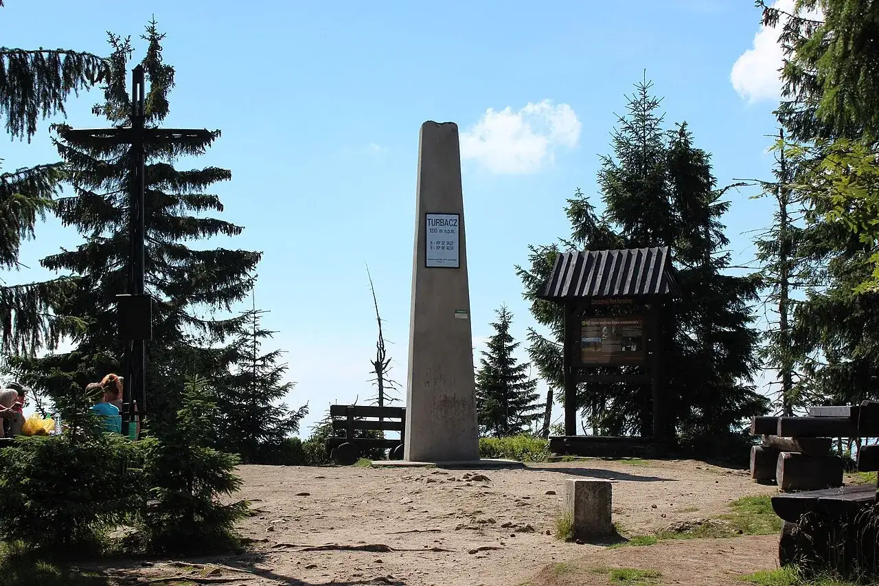 Na szczycie Turbacz, gdzie jest piękny widok, stoi obelisk. Wokół drzewa i ławki dla turystów.