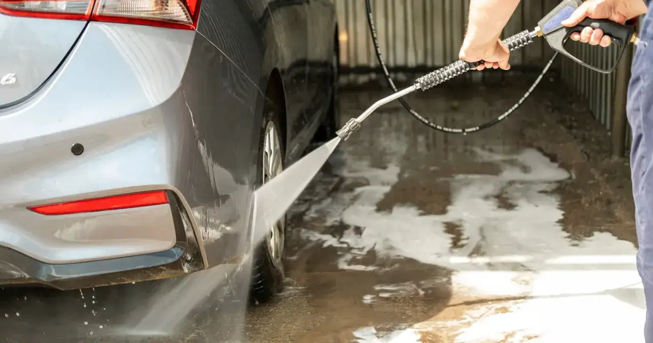 Pokazuję, jak dobrze umyć auto na myjni bezdotykowej, spłukując je wodą pod ciśnieniem.