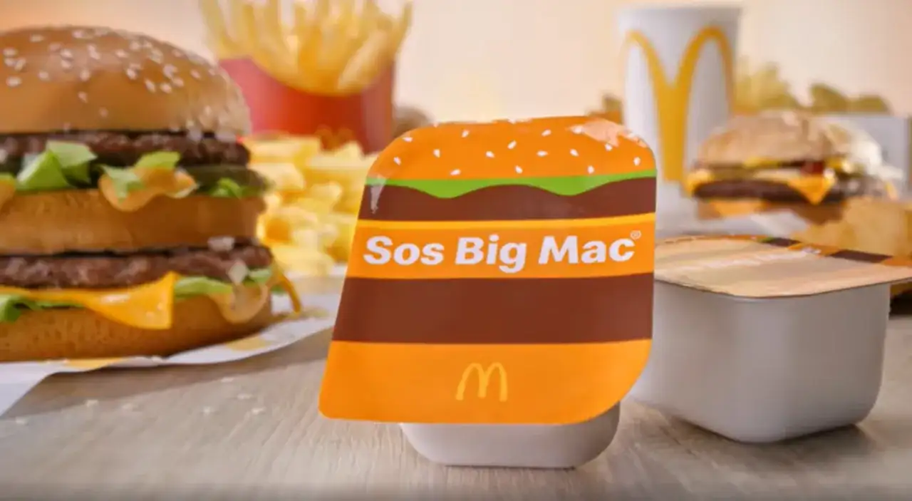 Sos Big Mac w opakowaniu imitującym bułkę, obok burgera i frytek. Idealny dodatek do Twojego ulubionego posiłku.