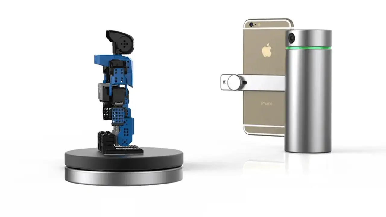 Zestaw do samodzielnego skanowania 3D: niebieski robot na obrotowej podstawie i iPhone z cylindrycznym skanerem.
