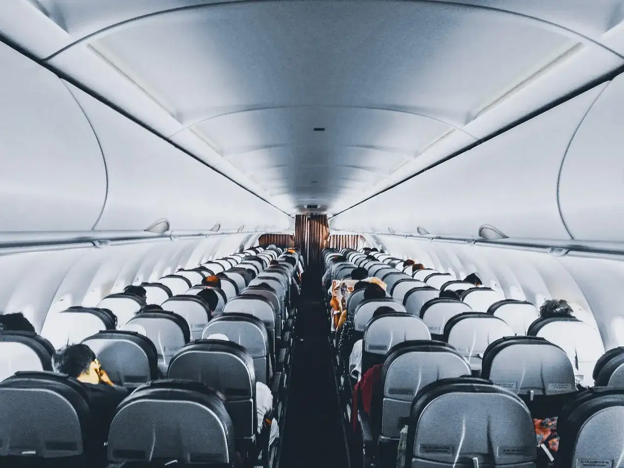 Wnętrze samolotu Wizz Air, rzędy siedzeń wypełnione pasażerami. Wizz Priority zapewnia komfortową podróż.