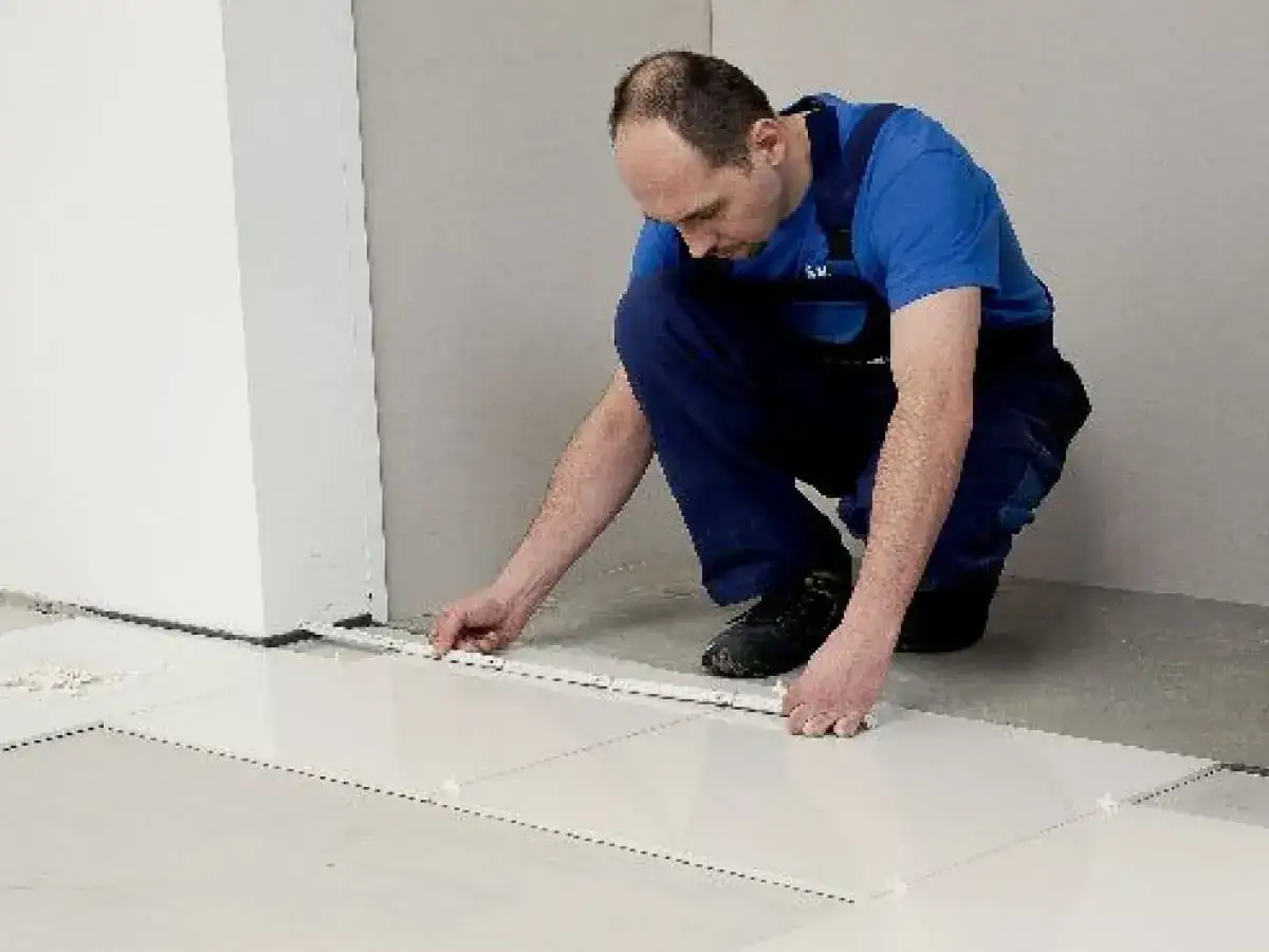 Fachowiec układa płytki 60x60, dbając o równe fugi. Wzory układania płytek są kluczowe dla estetyki.