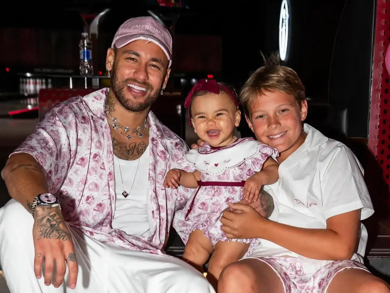 Neymar z synem i córką, wszyscy uśmiechnięci.