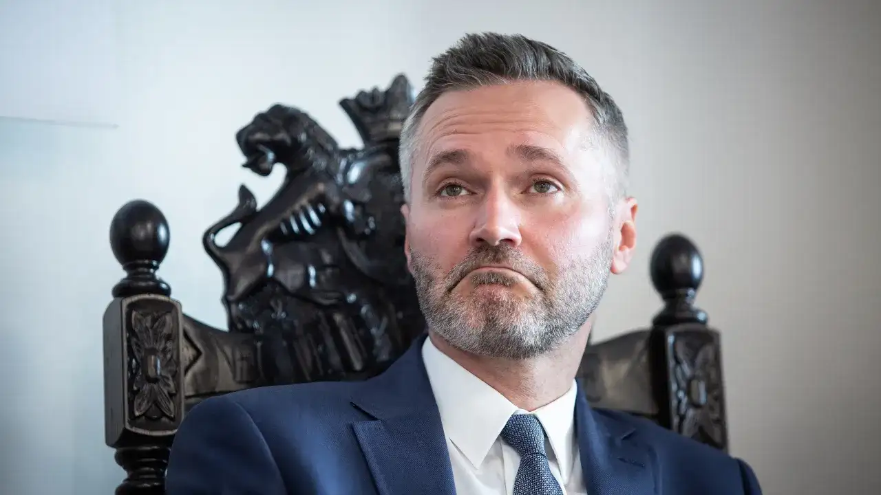Jarosław Wałęsa, w wieku, w którym doświadczenie miesza się z energią, siedzi na ozdobnym krześle.