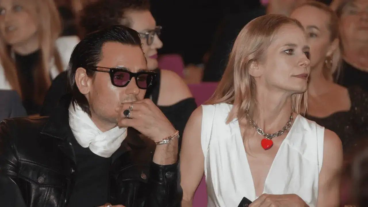 Magdalena Cielecka i Bartosz Gelner na widowni. Ona w białej sukni z naszyjnikiem w kształcie serca, on w skórzanej kurtce i okularach.