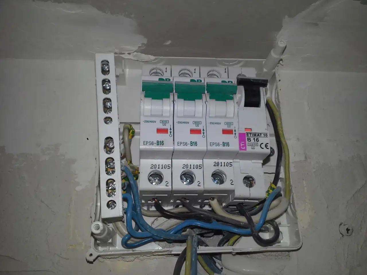 Widok z bliska na skrzynkę z bezpiecznikami i przewodami elektrycznymi.