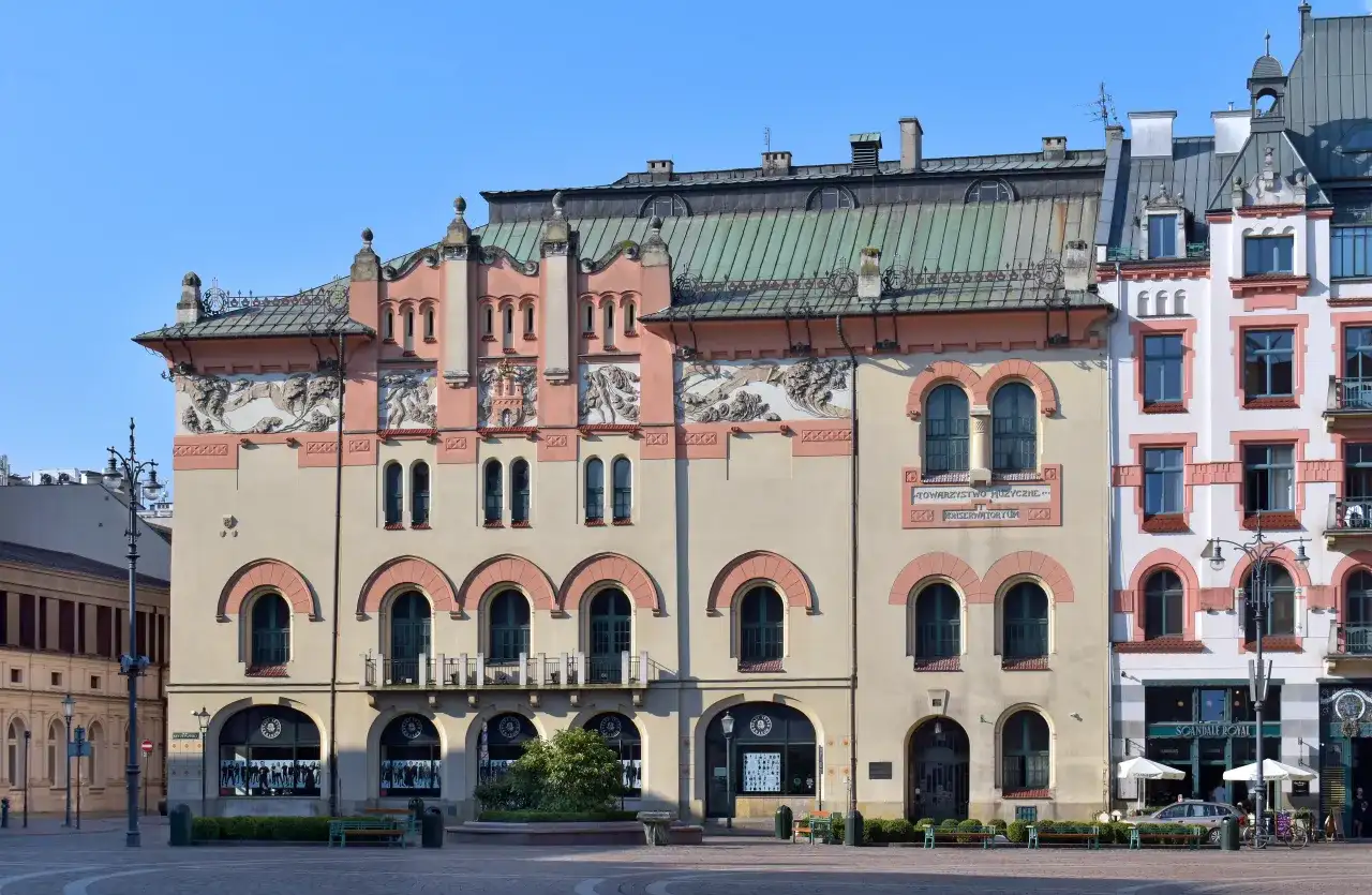Elegancka fasada Teatru Starego w Krakowie z ozdobnymi detalami i łukowymi oknami.