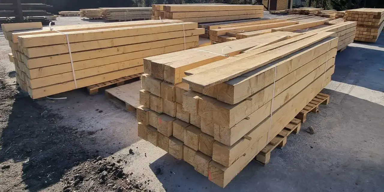 Stosy drewnianych belek, gotowe do transportu. Skład drewna machnik oferuje materiały budowlane najwyższej jakości.