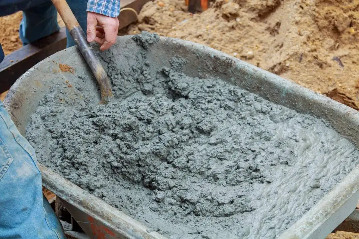Mieszanie betonu B20 w taczce. Właściwe proporcje składników są kluczowe dla uzyskania wytrzymałego materiału budowlanego.