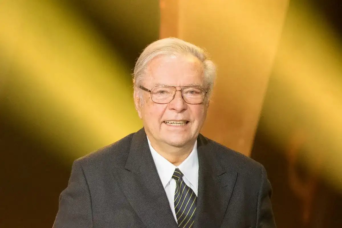 Uśmiechnięty Krzysztof Zanussi w garniturze, z okularami. Może opowiadać o swoich dzieciach.