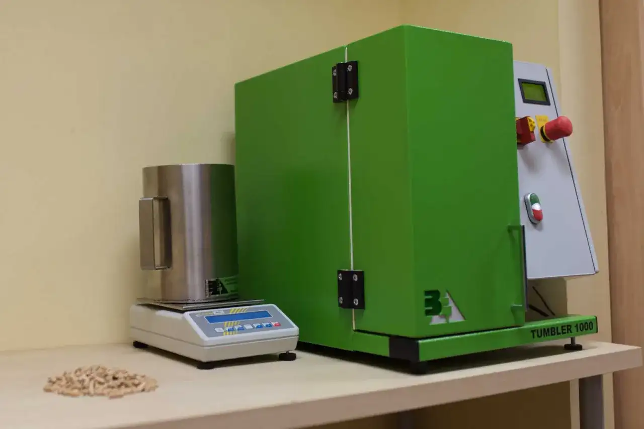 Sprzęt laboratoryjny do analizy pelletu, w tym waga i urządzenie Tumbler 1000, pomagają ustalić, jak sprawdzić kaloryczność pelletu.