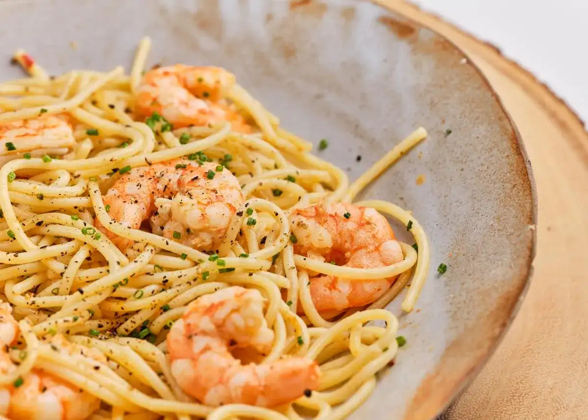 Espaguetis con gambas, un plato delicioso y fácil de preparar. La pasta se mezcla con gambas jugosas y se espolvorea con cebollino fresco.