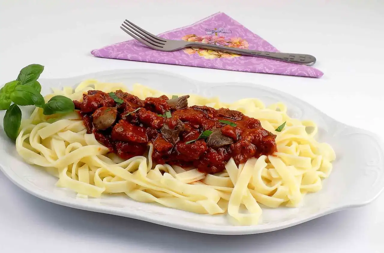 Serca drobiowe w sosie pomidorowym z grzybami podane na tagliatelle. Pyszny sposób, jak przygotować serca drobiowe.