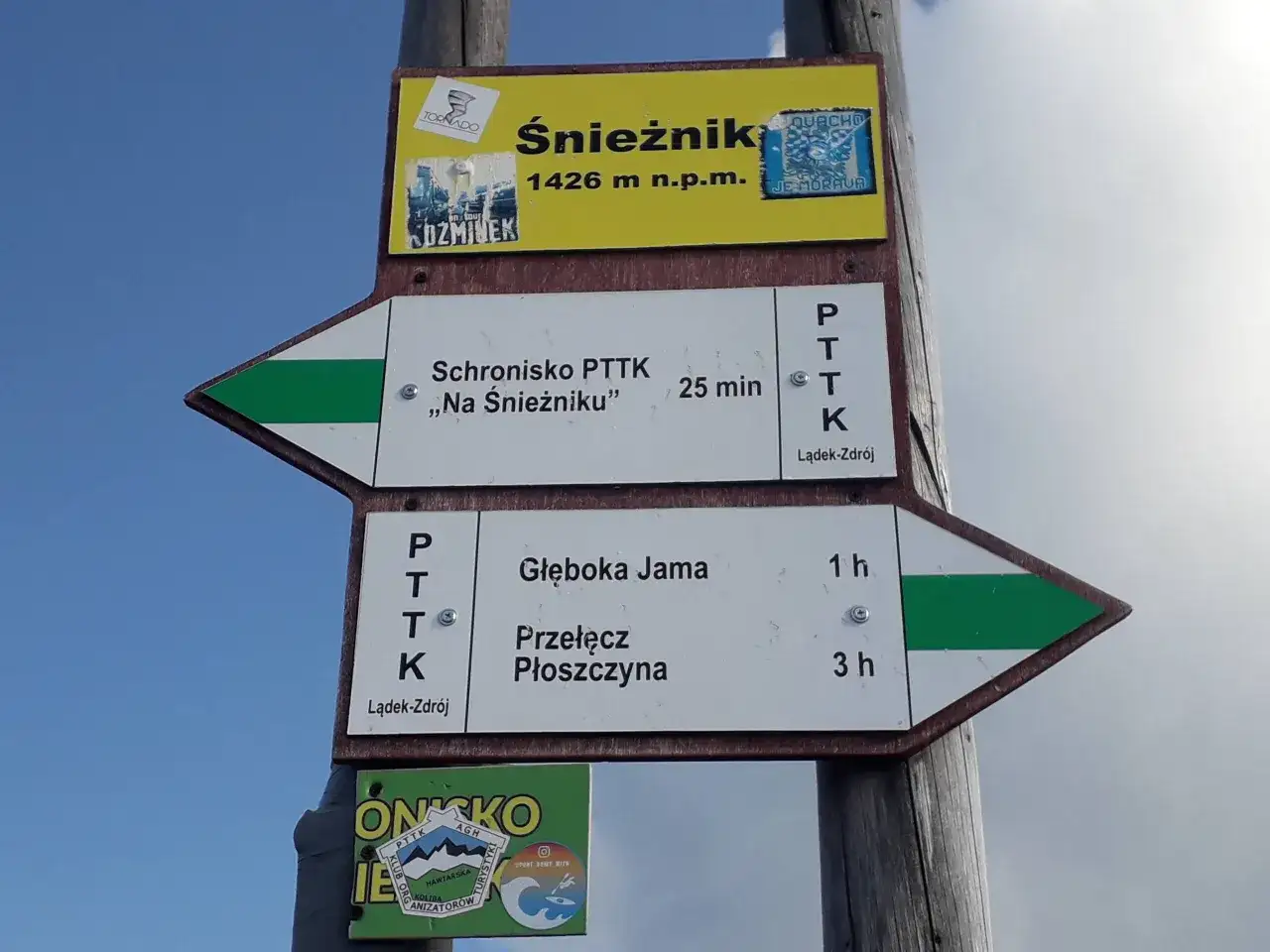 Znaki szlakowe na masywie Śnieżnika wskazują drogę do schroniska i na przełęcz.