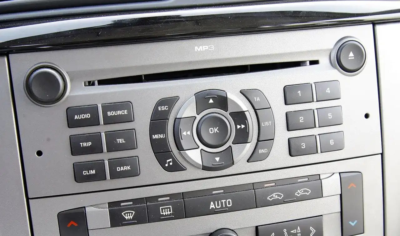 Panel radia samochodowego z przyciskami do wyboru stacji radiowych w Warszawie.