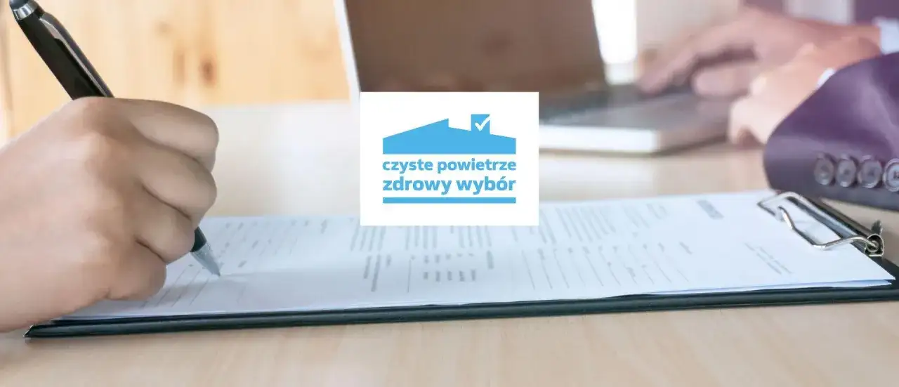 Dłoń pisząca na formularzu, logo "czyste powietrze zdrowy wybór".