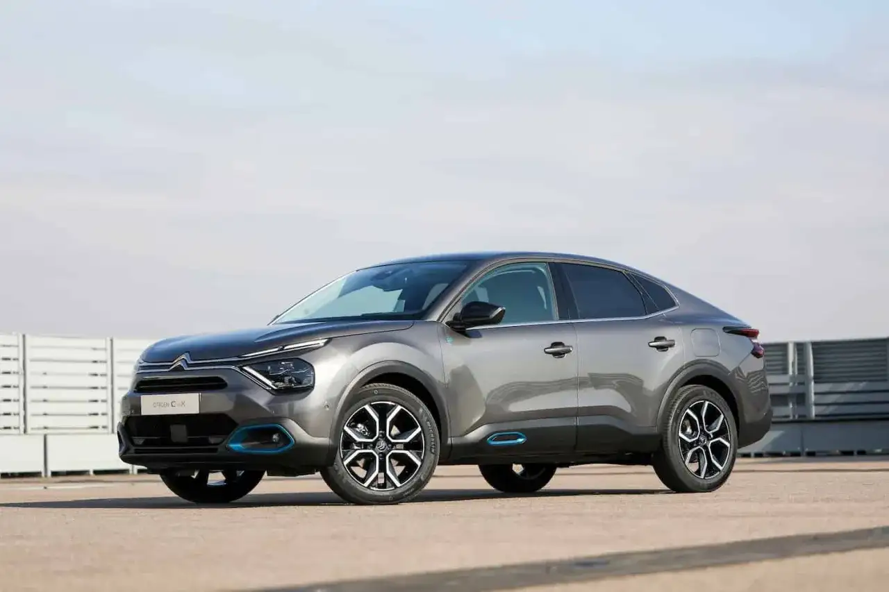Szary Citroen C4X z niebieskimi akcentami stoi na betonowym placu.