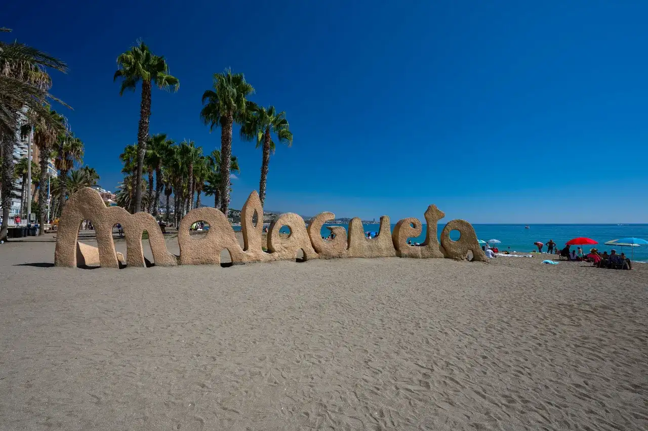 Piaskowy napis "Malagueta" na plaży, palmy i błękitne morze. Czy Malaga ma dostęp do morza? Tak, jak widać!