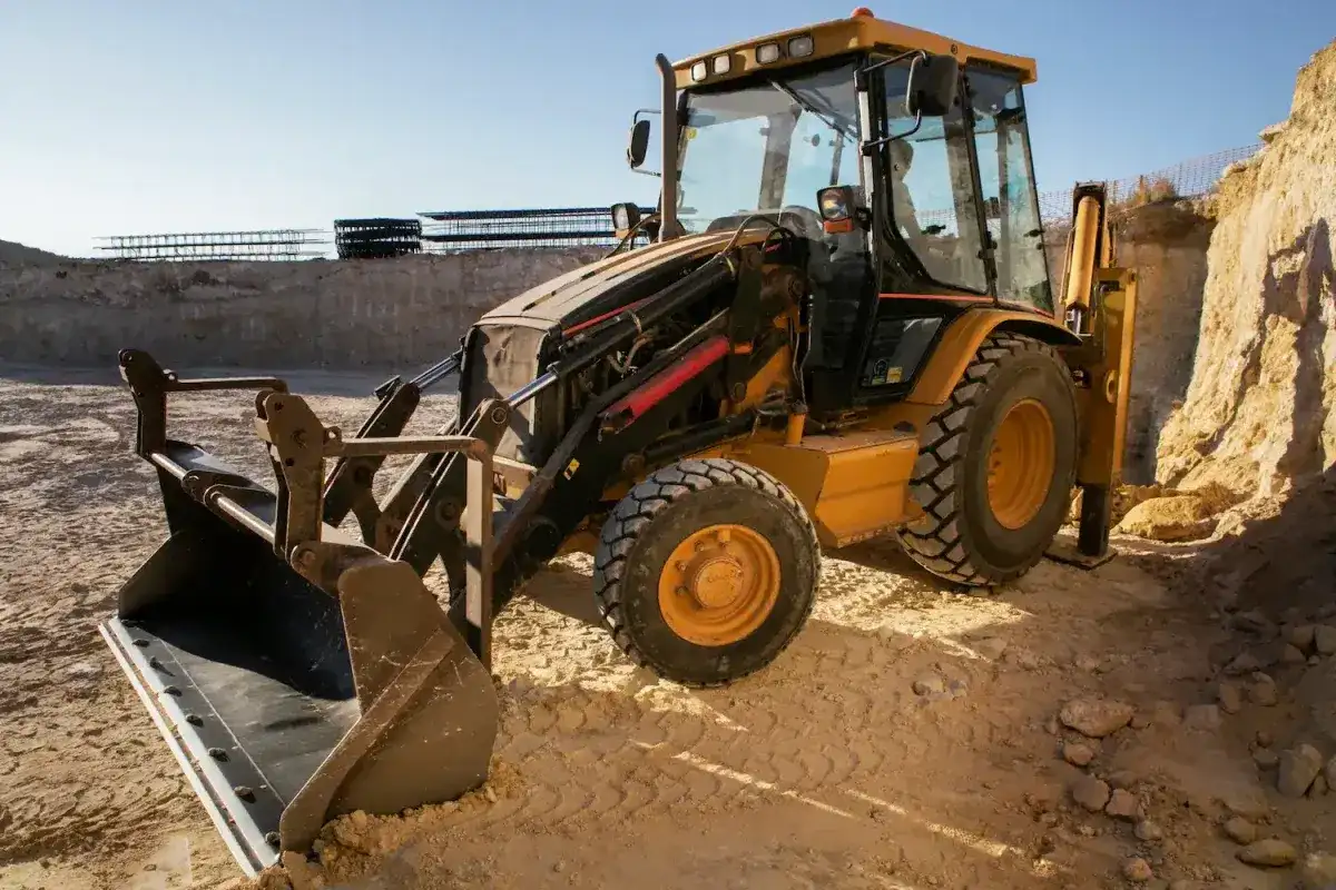 Żółta koparko-ładowarka JCB na budowie. Pytanie: jaki olej hydrauliczny do koparki jcb?