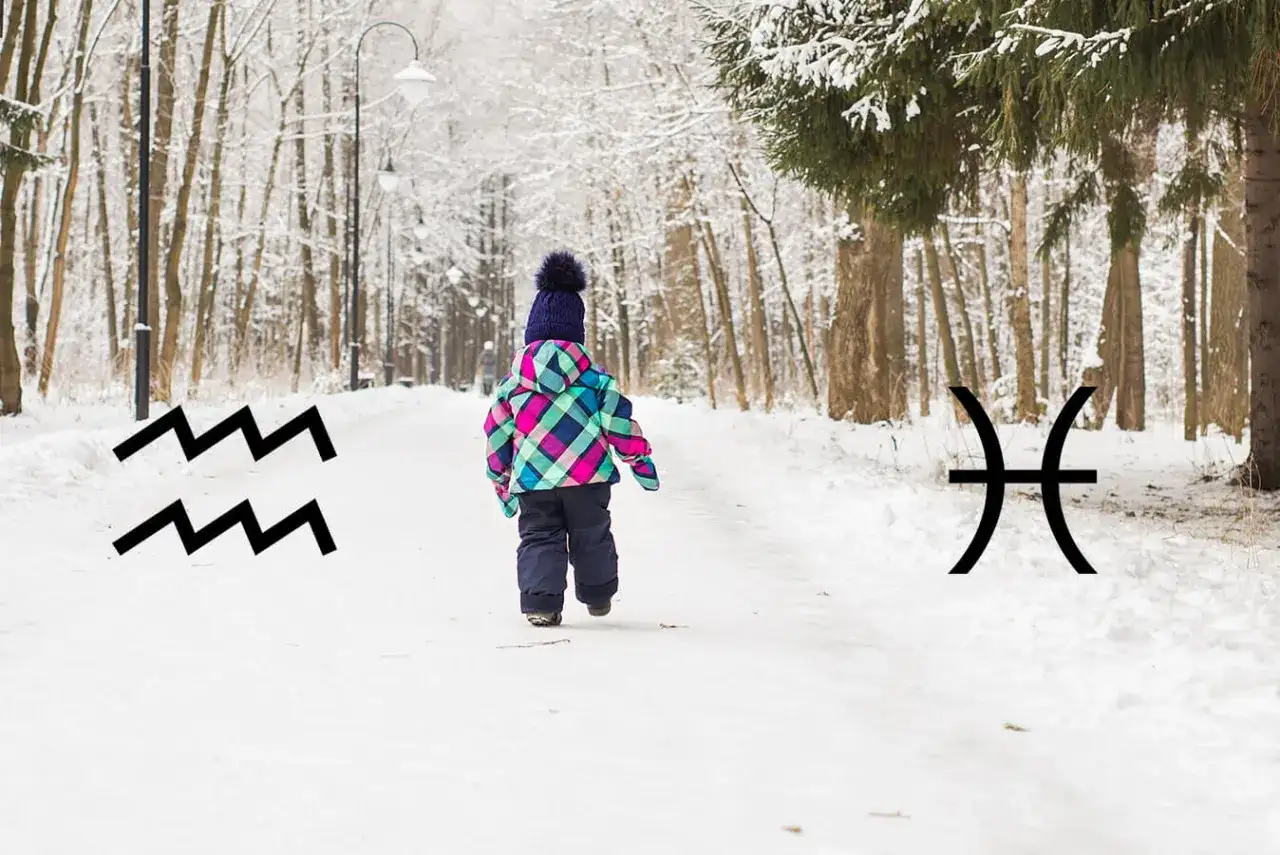 Dziecko w zimowym parku, obok symbole Wodnika i Ryb, sugerujące luty znak zodiaku.