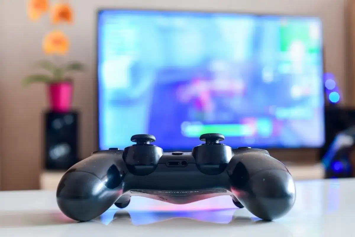 Czarny pad DualShock 4 na białym blacie, gotowy do gry na PC. Dowiedz się, jak podłączyć pada PS4 do PC, by cieszyć się grami na większym ekranie.