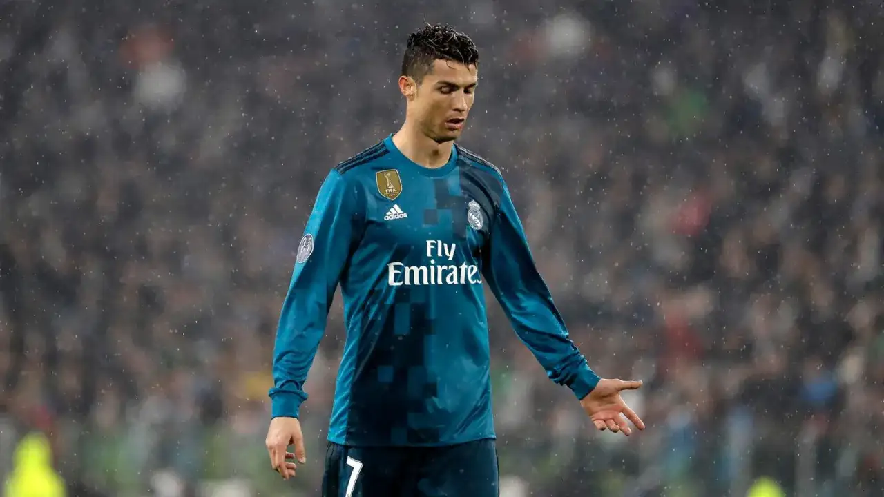 Piłkarz Cristiano Ronaldo w niebieskiej koszulce Realu Madryt, w deszczu. Ile hat tricków ma Ronaldo? Tego nie widać na zdjęciu.