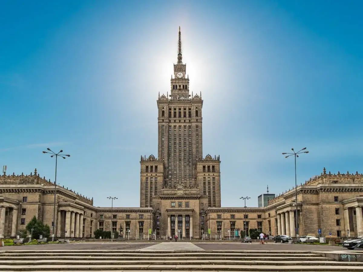 Imponujący Pałac Kultury i Nauki w Warszawie, jego monumentalna wysokość dominuje nad placem.