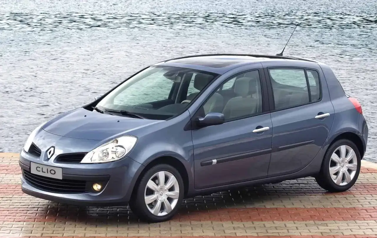 Niebieski Renault Clio 3 na tle wody, z widocznym rozmiarem opon.