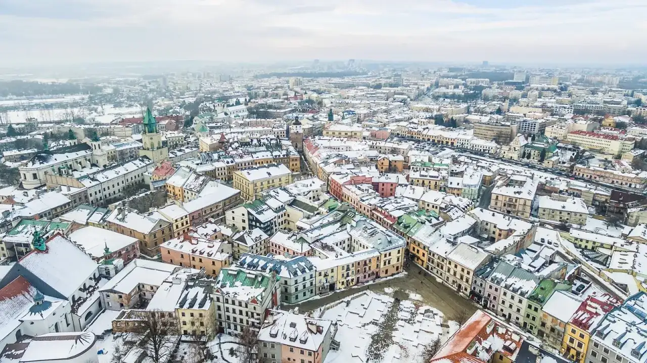Zimowy krajobraz Lublina pokryty śniegiem. Idealne miejsce na ferie zimowe 2026 lubelskie, z kolorowymi kamienicami i zabytkowymi kościołami.