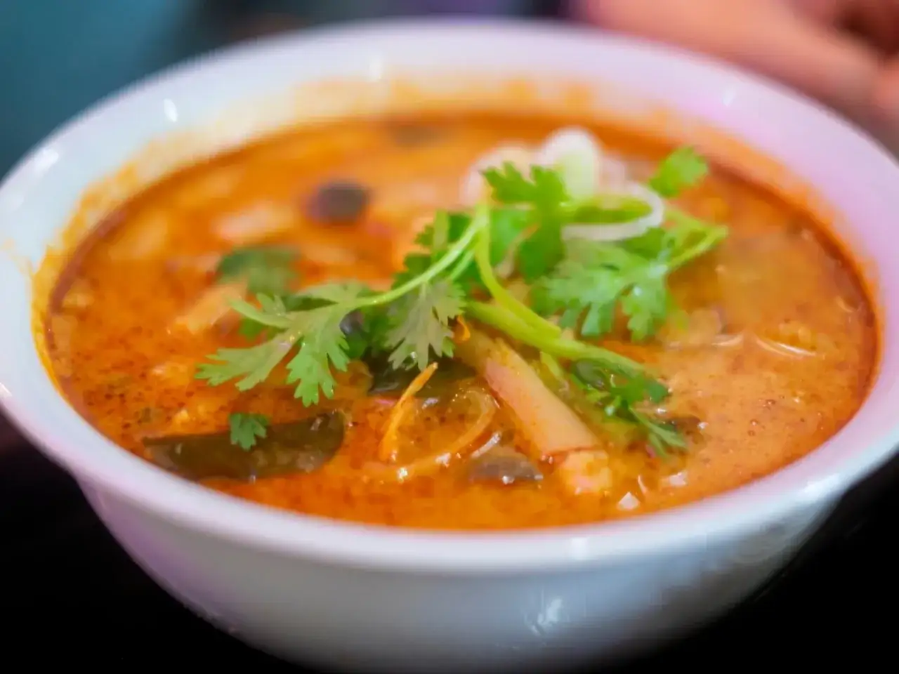 Aksamitna zupa tom yum z krewetkami, grzybami i świeżą kolendrą. Aromatyczny, pikantny bulion zachęca do spróbowania.