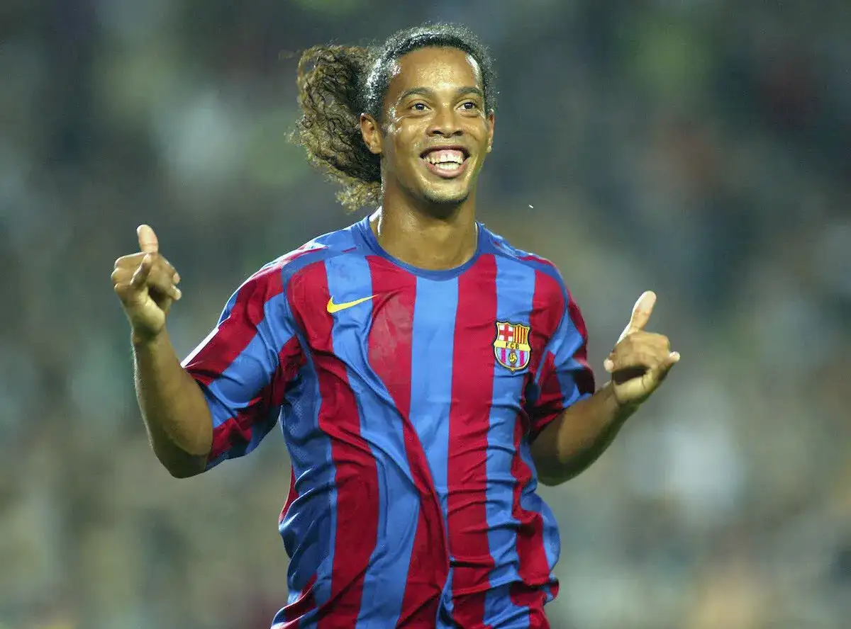 Ronaldinho w koszulce Barcelony, z charakterystycznym uśmiechem i uniesionymi kciukami, uosabia joga bonito.