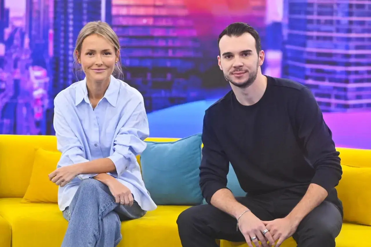 Olga Frycz i jej partner siedzą na kanapie.