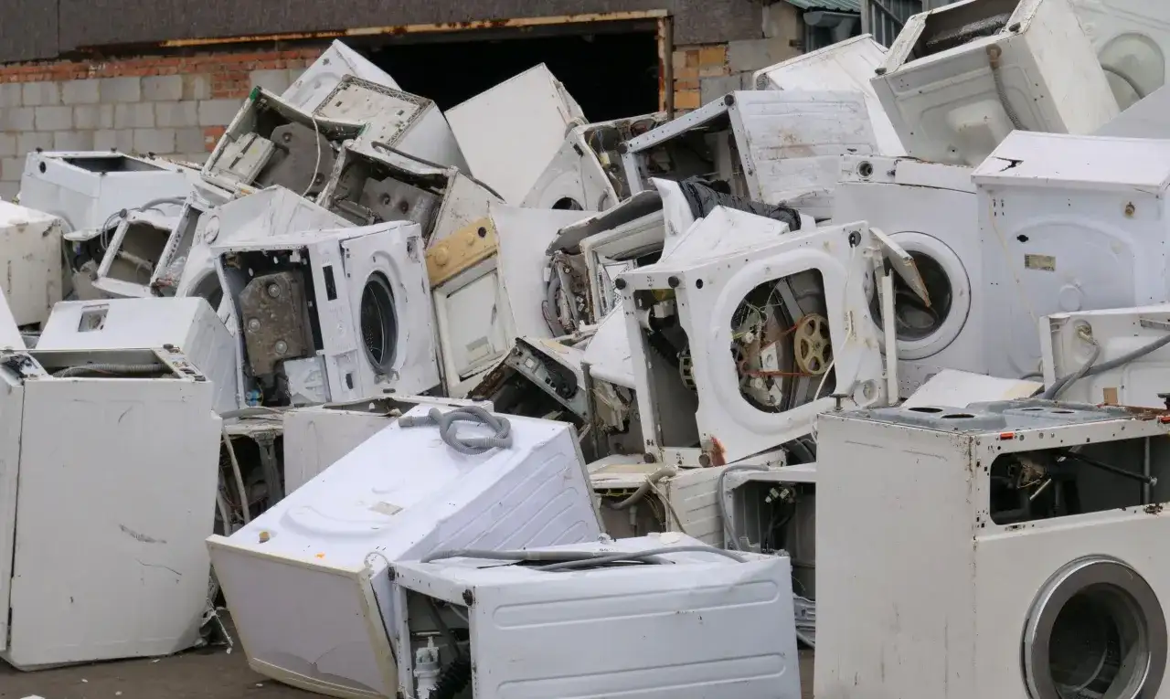 Góra złomu ze starymi pralkami. Zastanawiasz się, co zrobić ze starą pralką? Tutaj znajdziesz odpowiedź – to miejsce na recykling.