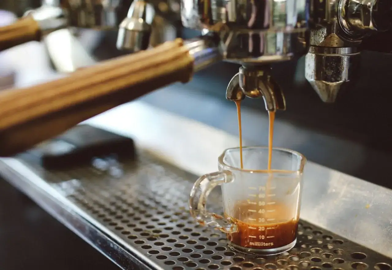 Ekspres do kawy parzy espresso do małej szklanki z miarką.