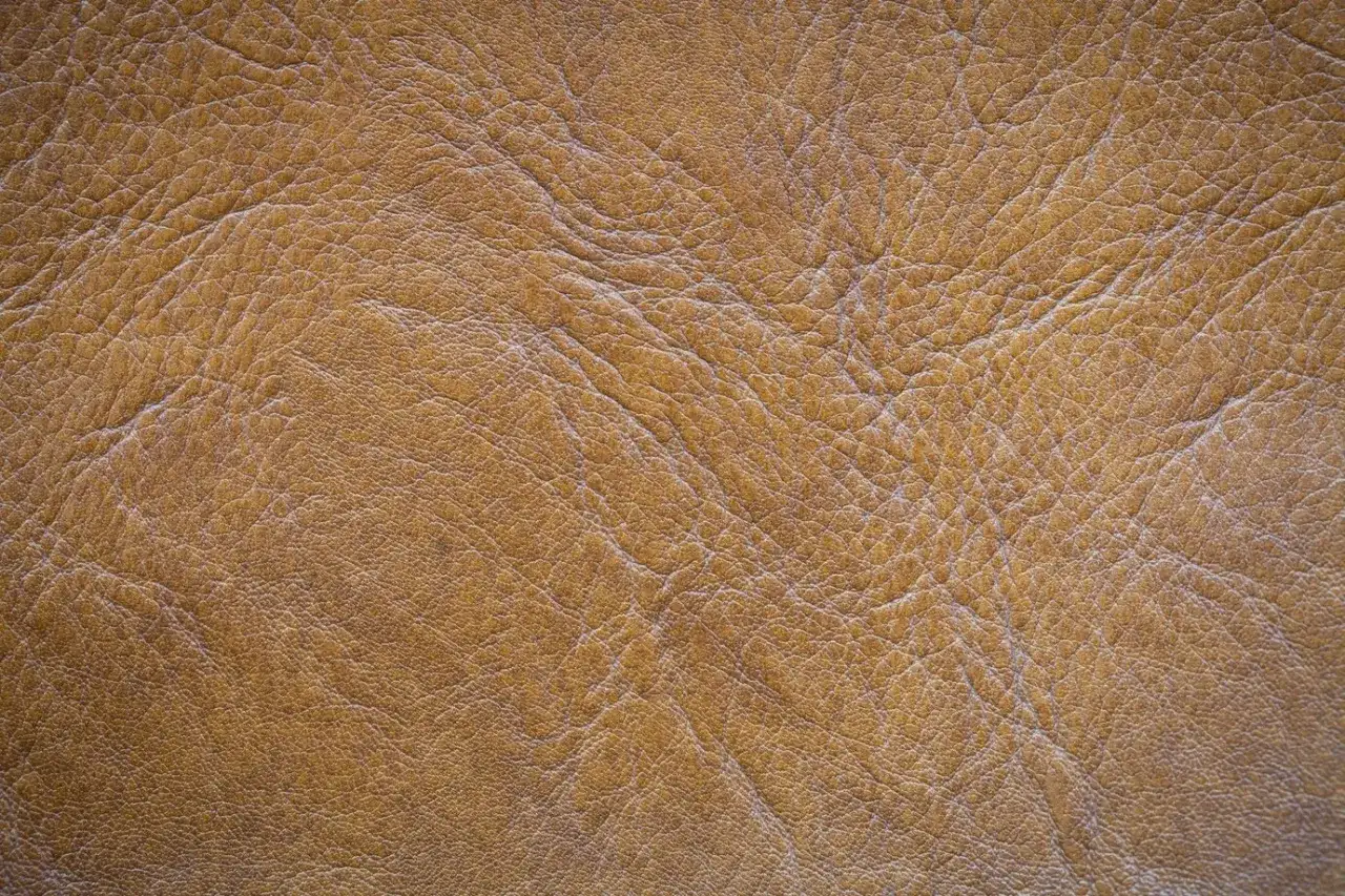 Textura de piel de serraje marrón con arrugas y pliegues. Este material es resistente y la piel de serraje se puede mojar sin problemas.