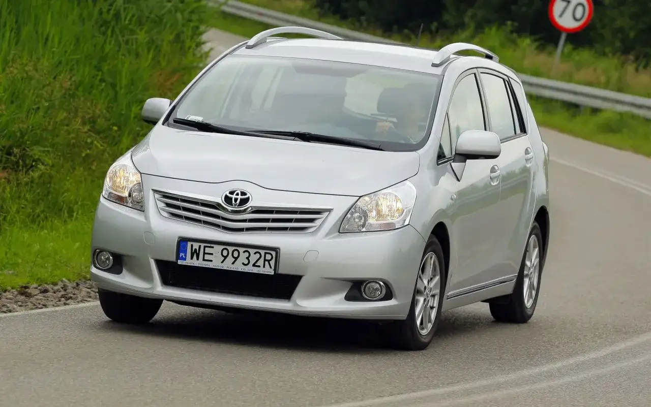 Srebrny Toyota Verso S jedzie po drodze, za kierownicą siedzi osoba.