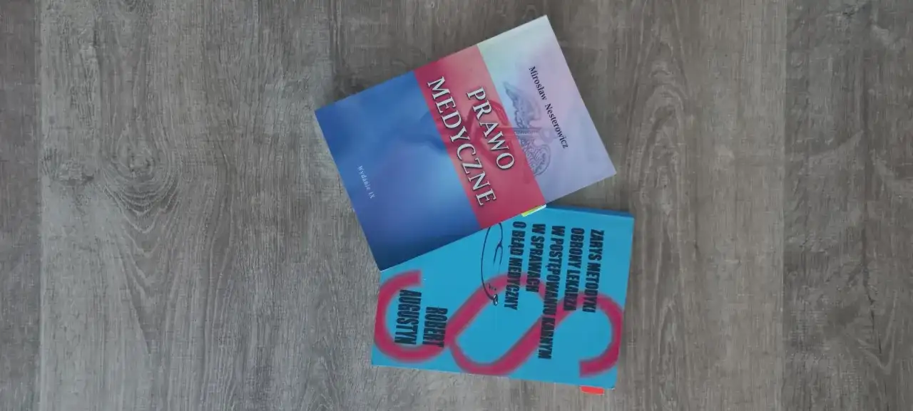 Dwie książki o prawie medycznym i błędach medycznych na drewnianym tle.