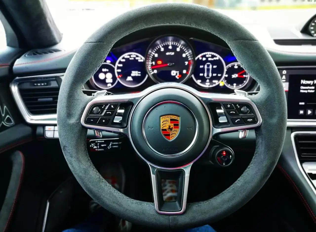 Kierownica Porsche Panamera GTS z alcantary, z emblematem Porsche i wskaźnikami GTS.