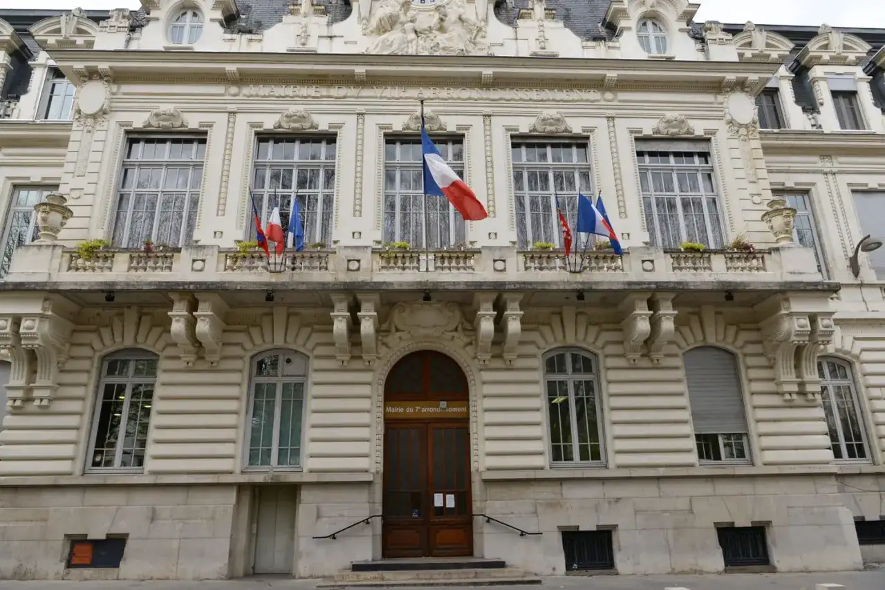 Mairie du 7ème arrondissement, avec drapeaux français. Si vous vous demandez combien de temps pour déclarer un décès, ce bâtiment est un lieu où trouver des informations.