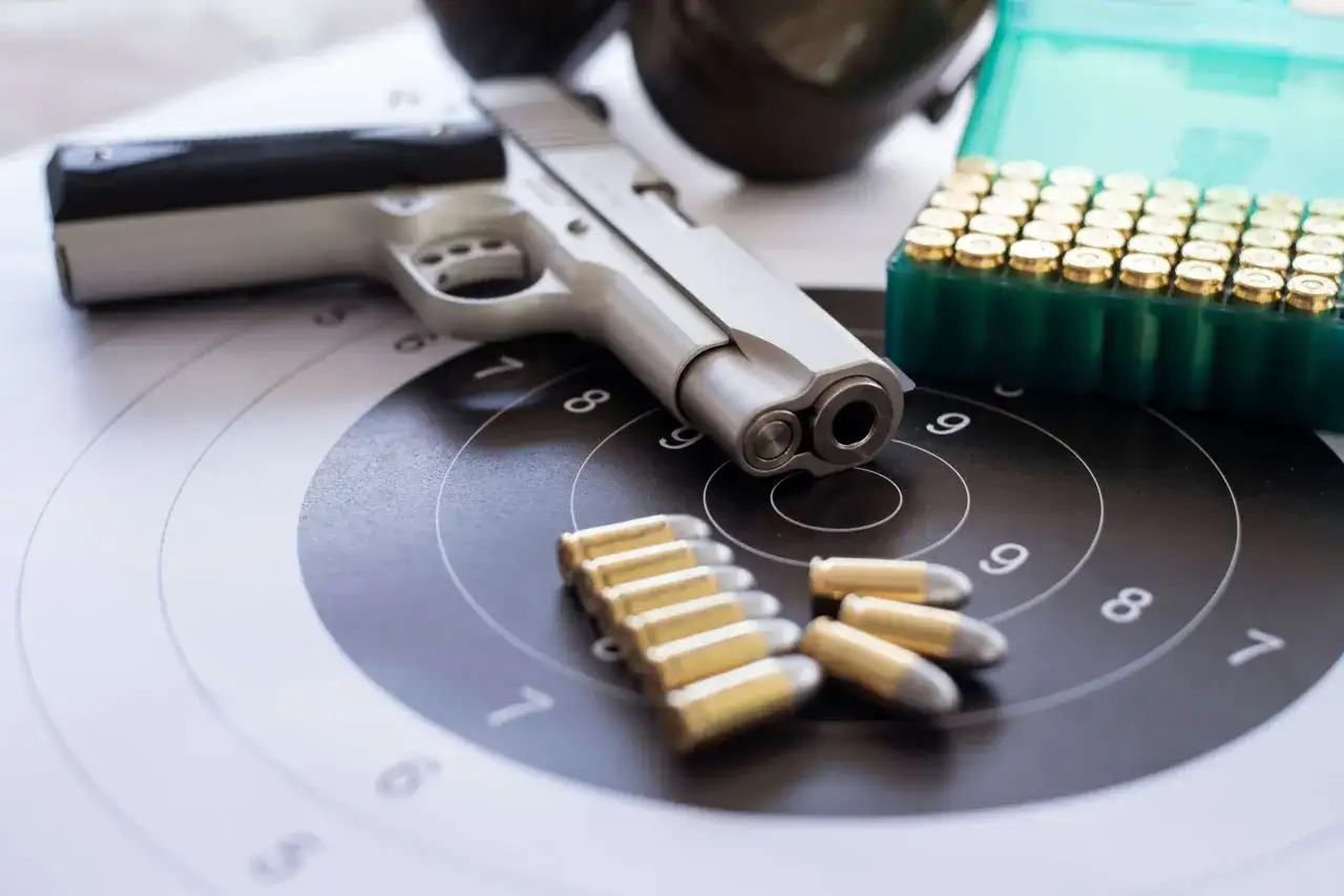 Pistolet, amunicja i tarcza strzelnicza. Wszystko gotowe do treningu, który może być częścią starań o pozwolenie na broń.