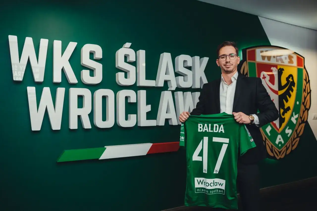 Dyrektor sportowy WKS Śląsk Wrocław, Balda, prezentuje zieloną koszulkę z numerem 47.