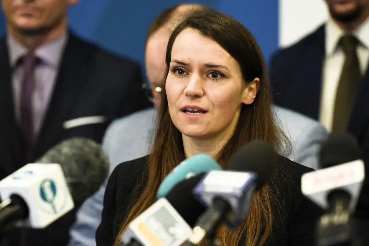Agnieszka Pomaska przemawia do mediów. W tle widać mężczyzn, być może jej rodziców lub współpracowników.