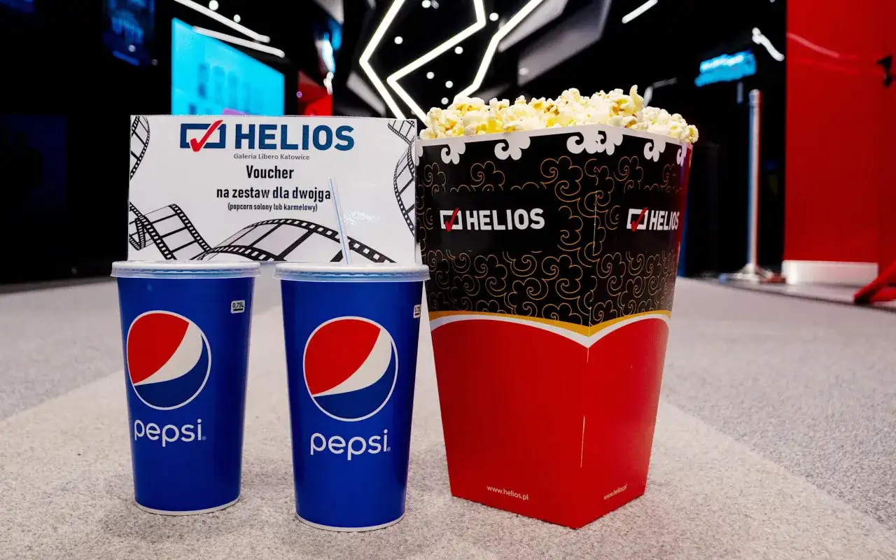 Duży popcorn Helios i dwa napoje Pepsi. Zastanawiasz się, ile kosztuje duży popcorn Helios? Ten zestaw dla dwojga z voucherem to świetna opcja.